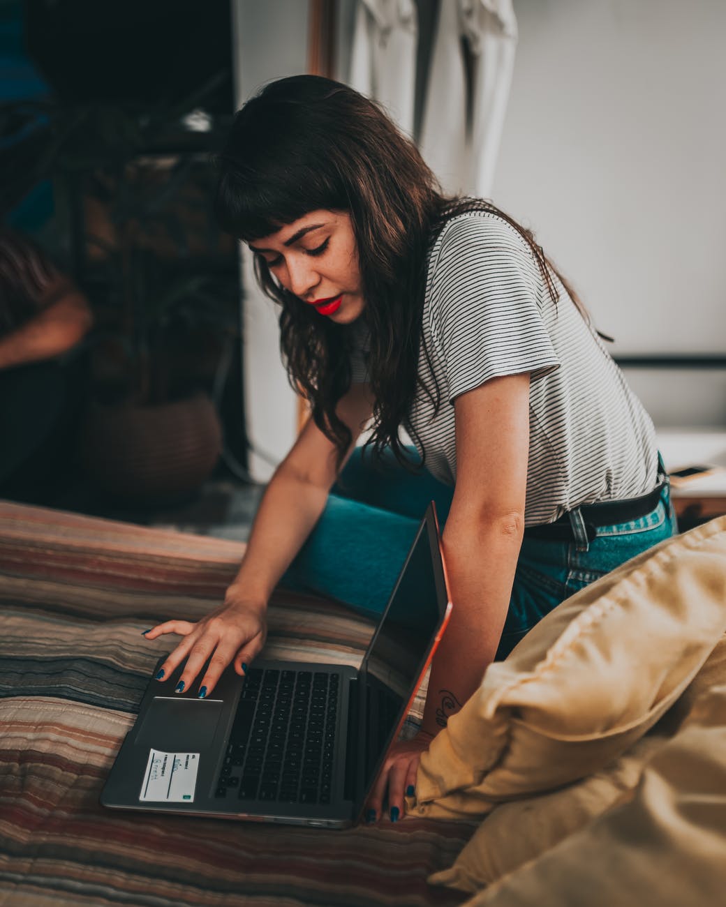 woman using laptop on mat and demonstrating screen smart money bro