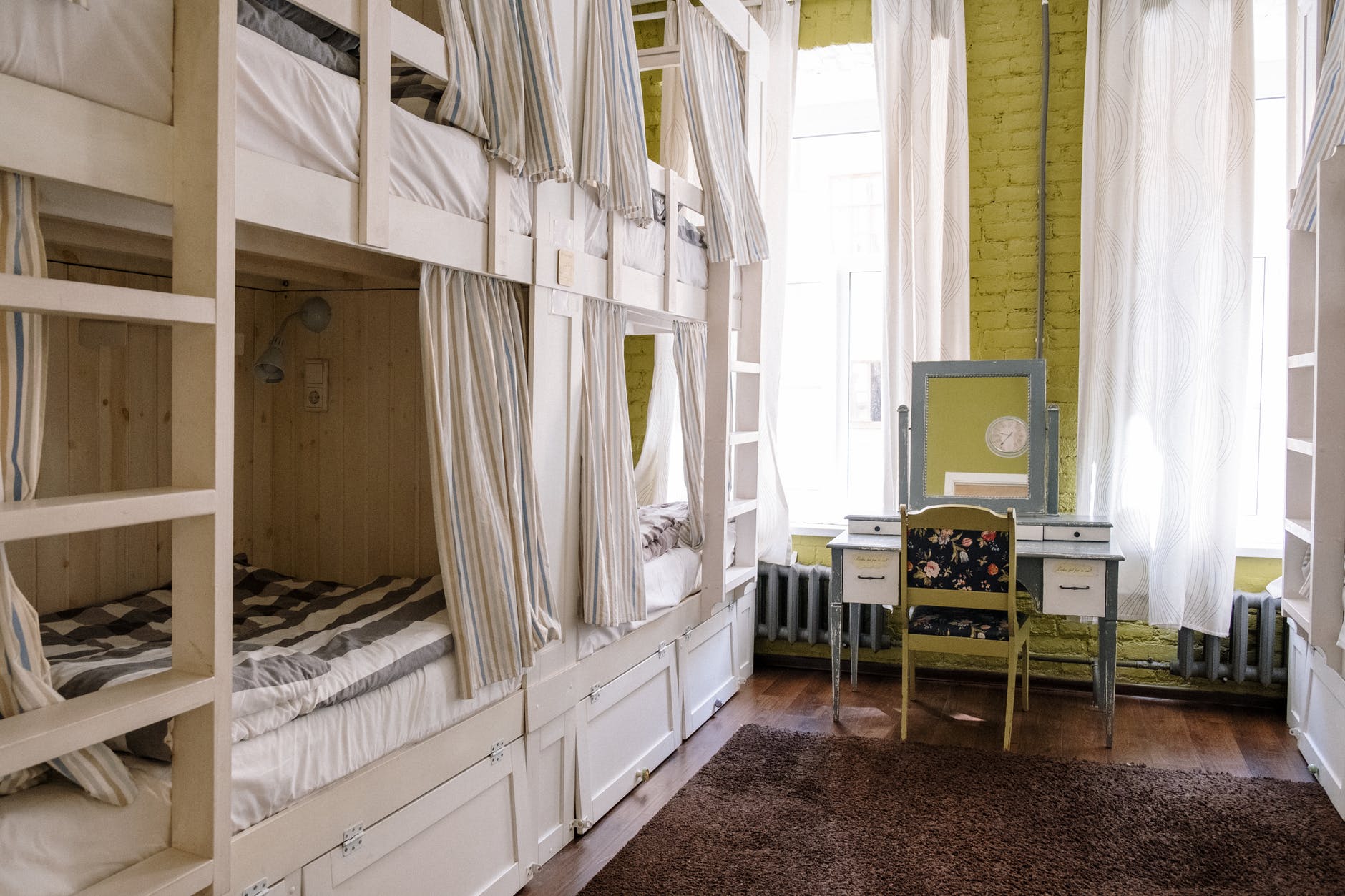 white wooden bed frame near white window curtain