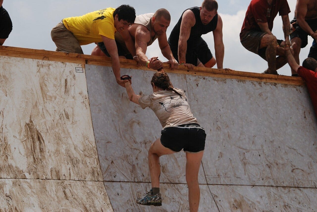 girl, mud, run. 3 people helping another person over a wall. smart money bro.