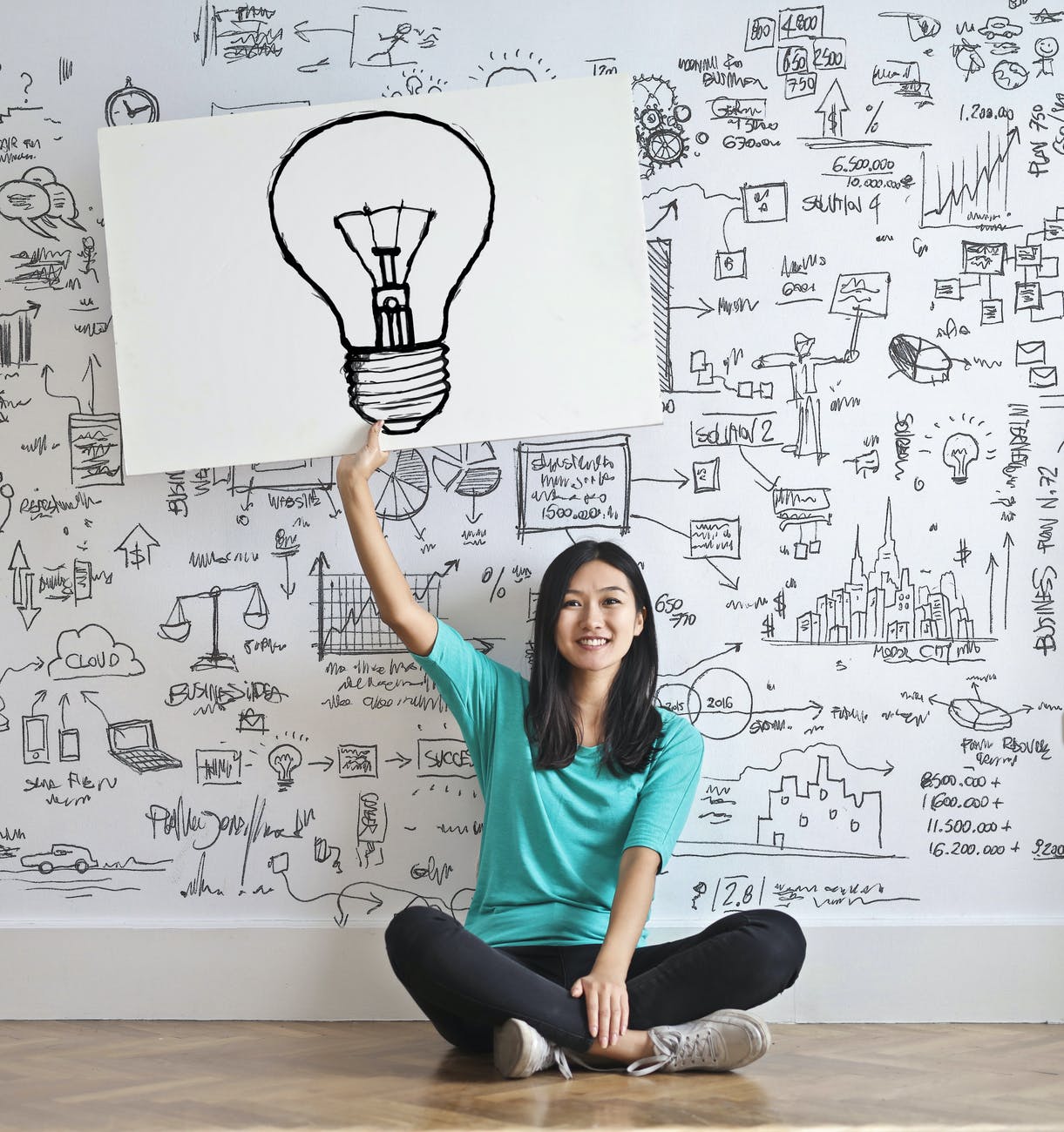 woman draw a light bulb in white board