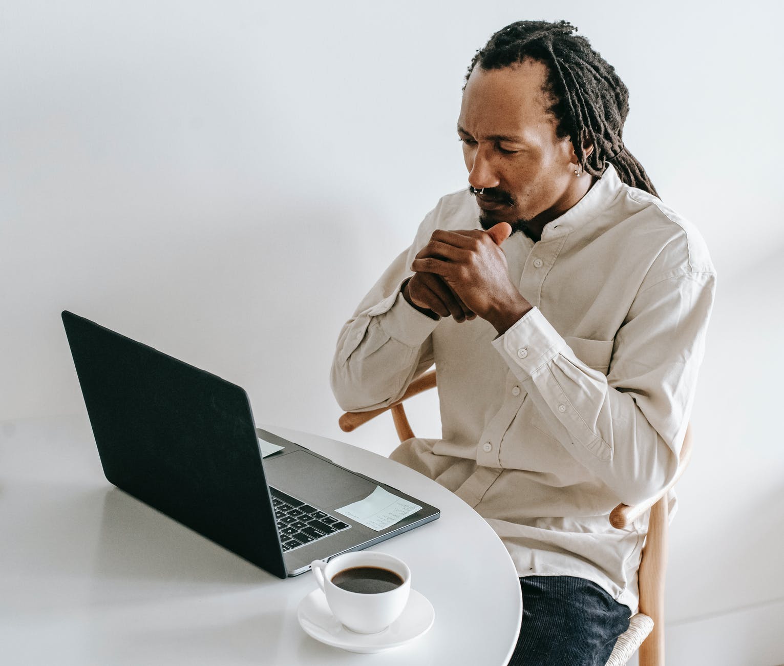 serious black man working on laptop in light room