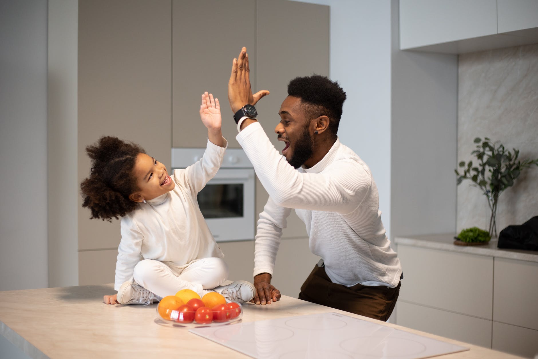 joyful black father giving high five to adorable daughter. smart money bro.