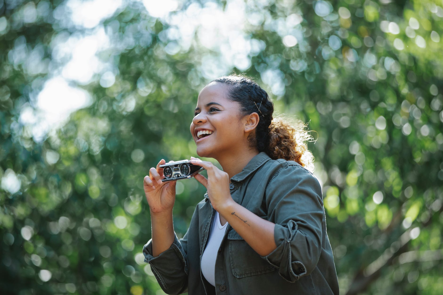 cheerful ethnic woman with small binocular. smart money bro.