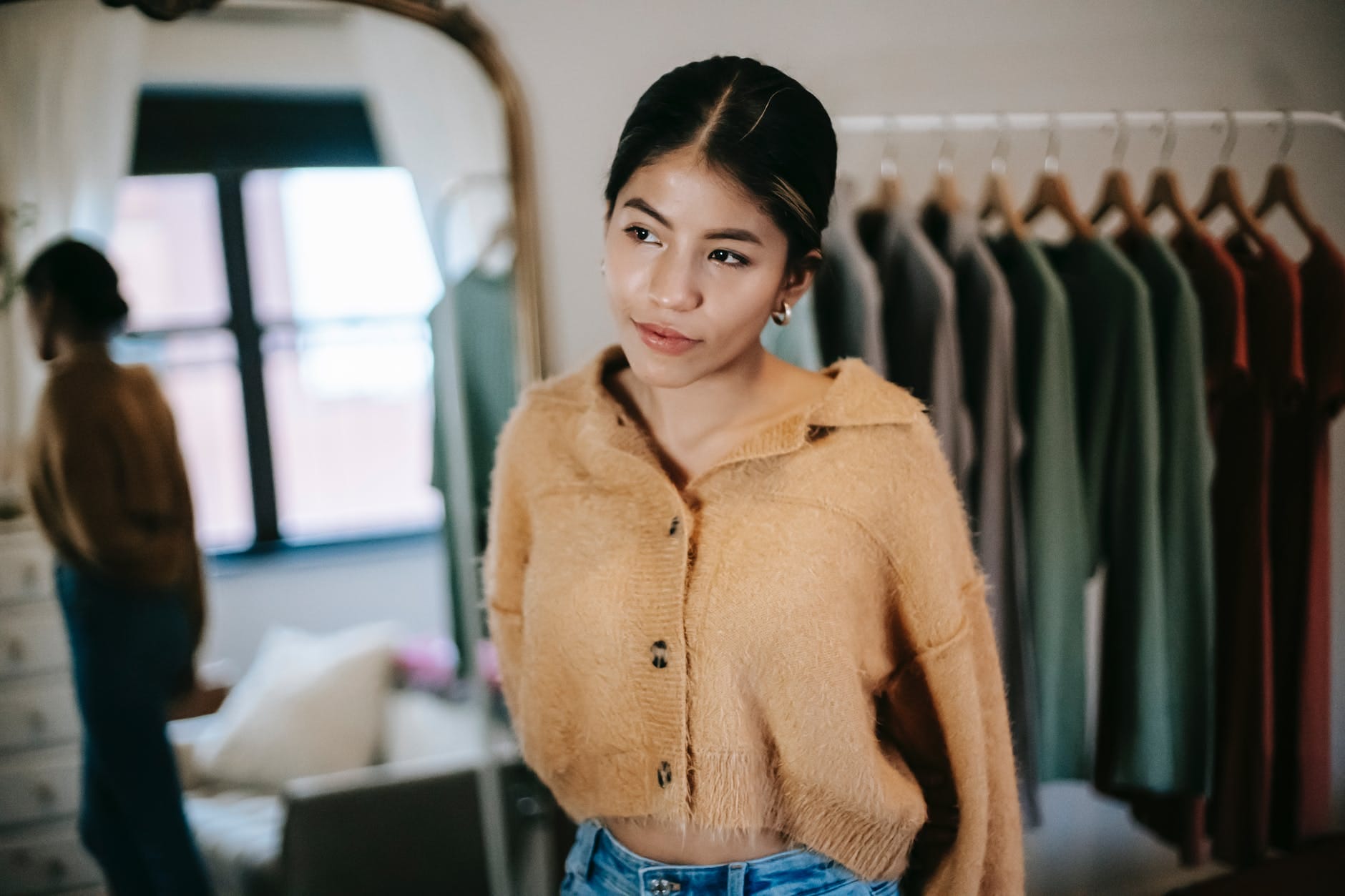 ethnic woman in trendy clothes in room