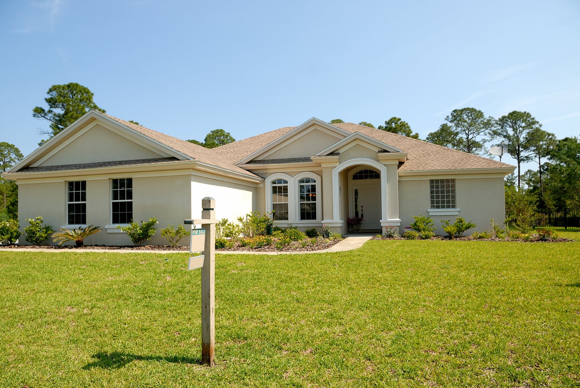 white and brown concrete bungalow under clear blue sky, smart money bro