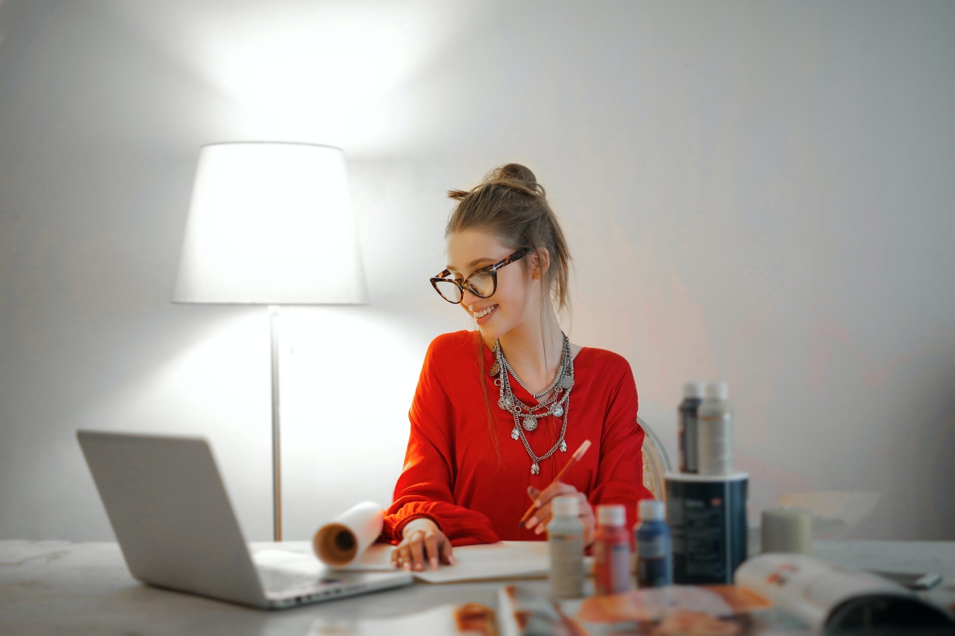 woman in red long sleeve shirt looking at her laptop, valuing stocks and stock market terms