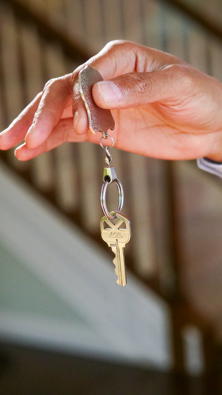 person holding a keychain with key, do you have to like your tenants, smart money bro