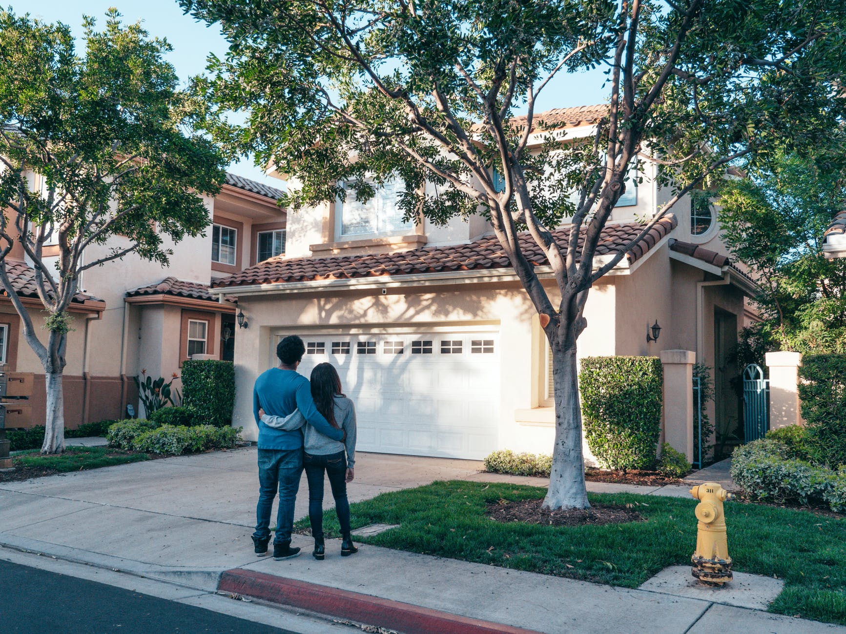 couple standing in front of their house, who wants to be a millionaire, smart money bro