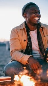 man laughing while holding a beer bottle ways to practice self-care, smart money bro