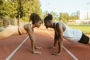 man and woman doing push ups, ways to practice self-care, smart money bro